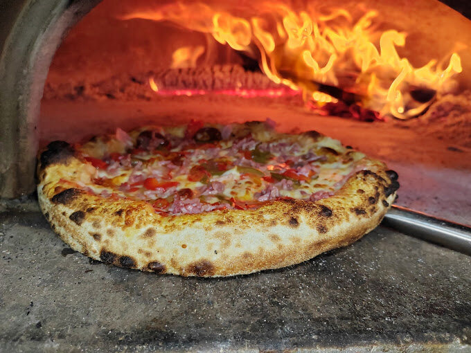 Pizza cuite dans notre four à bois traditionnel